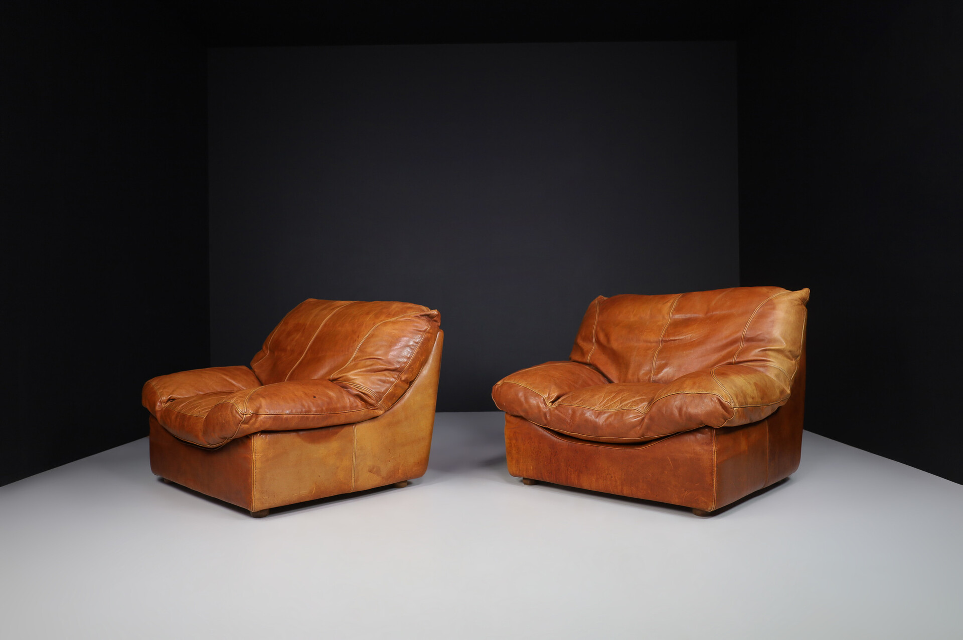 Mid century modern Oversize patinated Cognac leather lounge chairs, France 1970s Late-20th century